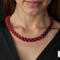 Close-up of model wearing Crimson Noir Kumihimo beaded necklace with red and black glass seed beads against black dress